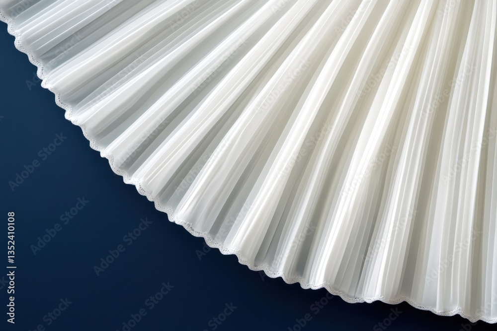 Aufkleber elegant white pleated fabric displayed on a deep blue surface showcasing intricate texture and craft