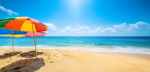 Fototapeta premium Golden sand beach with umbrellas and bright blue water
