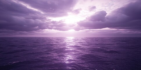 Purple ocean with cloudy skies and sun shining through them