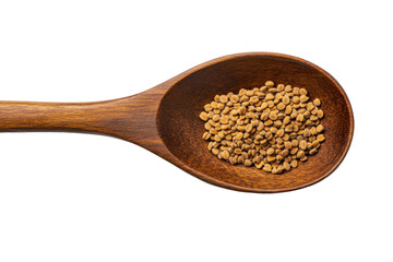 Wooden spoon filled with brown fenugreek seeds on a white surface in a close up detailed shot