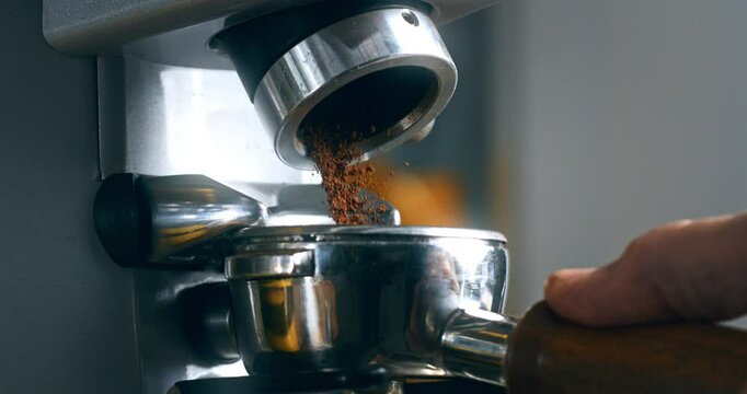 Super Slow Motion of Fresh Ground Coffee Dispensing into Portafilter from Grinder &ndash; Barista Hand Holding Handle, Espresso Preparation in Professional Brewing Setup at 1000 fps