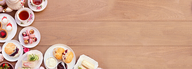 Afternoon tea corner border against a light brown wood banner background. Vintage tea set, finger...