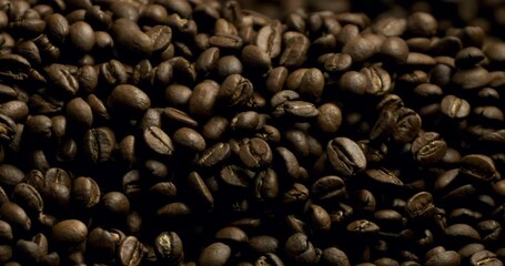 Super slow motion macro of fresh flavorful aromatic roasted coffee beans in rustic bag are falling on wooden table in coffee production shop at 1000 fps. - Powered by Adobe