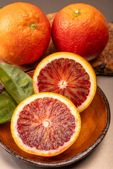 Sicilian sweet juicy yellow and red blood oranges with green leaves close-up