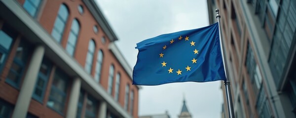 European Union flag waving against city buildings. Symbol of EU, integration, peace, cooperation. Blue flag with yellow stars represents unity of Europe. Economic alliance, international relations,