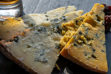 Cheese plate, English cow milk semi-soft, crumbly old blue stilton and blue shropshire cheeses sliced