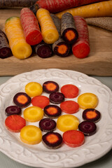 Colorful fresh raw purple, yellow, red and purple-orange carrots roots vegetables from greenhouse in the Netherlands