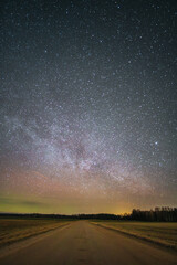 Country road at night with a gorgeous starry sky where the Milky Way is visible on a small northern light