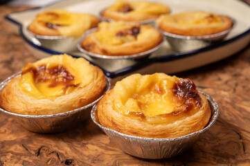 Portugal's traditional sweet dessert Pastel de nata egg custard tart pastry in cup close up on wooden background