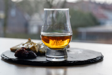 Whiskey and cheese pairing, tasting whisky glass and plate with sliced blue stilton and blue shropshire cheeses, Great Britain food and drink