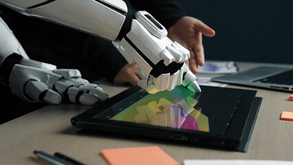 A robotic hand engages with a tablet showcasing vibrant data visuals, symbolizing advanced technology integration in a modern office setting.Noogenesis