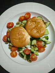Delicious smoked cheeses served with fresh cherry tomatoes, cucumber, and olives salad