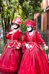 Venice, Italy - People dressed in carnival masks are photographed by tourists in the scenery of the ancient Venetian palaces