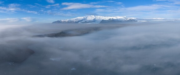 Dawn over the clouds. Wonderful calm heavenly landscape. Foggy morning. 
Iceberg floating in Jokulsarlon glacier lagoon at Vatnajokull national park, Iceland