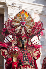 Venice, Italy - People dressed in carnival masks are photographed by tourists in the scenery of the ancient Venetian palaces