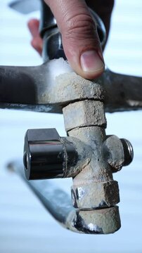A rusty water faucet. Outdated plumbing. A broken faucet with lime coating.