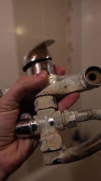 A rusty water faucet. Outdated plumbing. A broken faucet with lime coating.