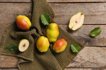 Sweet ripe pears and leaves on wooden background