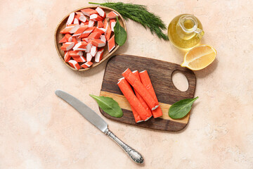 Wooden board nd plate with tasty crab sticks on beige background © Pixel-Shot