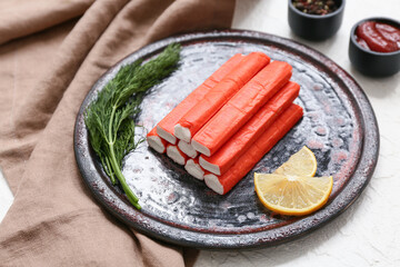 Plate with tasty crab sticks and different spices on white background © Pixel-Shot