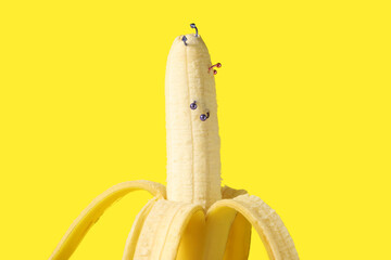 Banana with piercing on yellow background