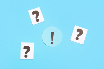 Paper question and exclamation marks on color background