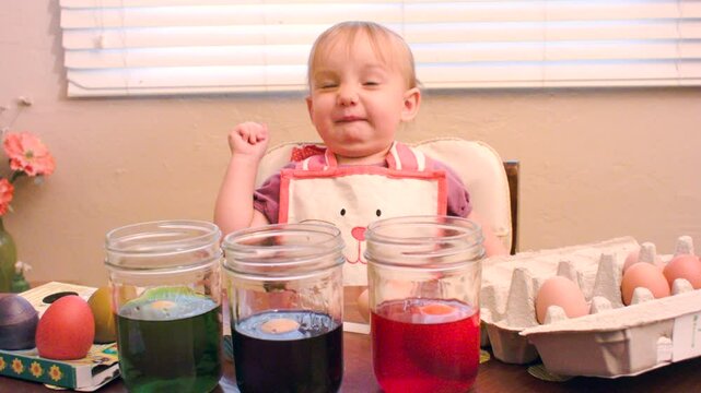 Little Girl making Yucky Face while Dyeing Easter Eggs