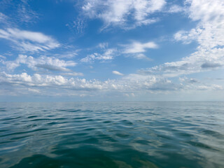 Calm ocean view with rippling water under a cloudy sky. Endless sea horizon with gentle waves and...