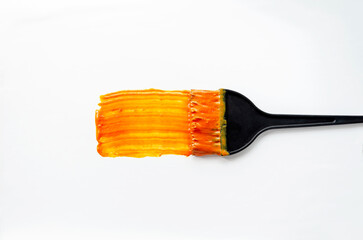 Orange Hair Dye on Brush Creating Vibrant Strokes