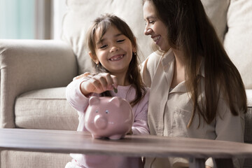 Building financial habits. Cropped close up smiling young mom support happy little kid daughter...