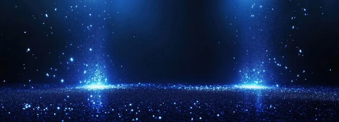 Obraz premium Blue glitter sparkles on dark background with light beams.