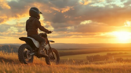 Fototapeta premium Rider on Dirt Bike Enjoying Sunset Over Scenic Valley Landscape