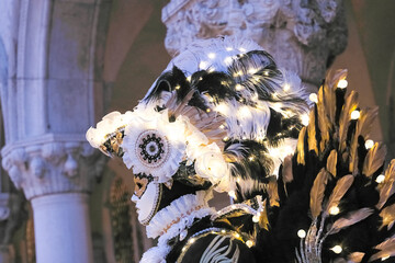 Venice, Italy - People dressed in carnival masks are photographed by tourists in the scenery of the ancient Venetian palaces