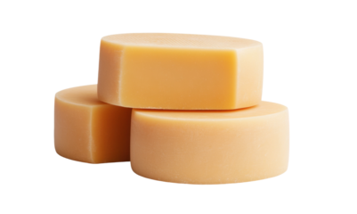 Stacked orange beeswax discs isolated against white background, cut out