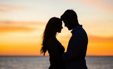 Fototapeta premium A silhouette of a couple standing close together on the beach at sunset, sharing an intimate moment as the golden sun sets behind them.