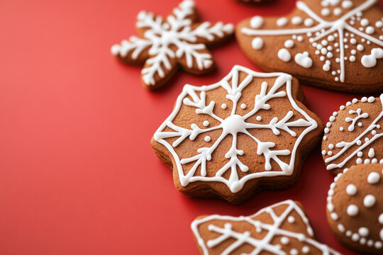 Christmas gingerbread cookies decorated with icing lying on red background