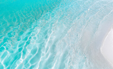 Obraz premium A close-up of clear, shimmering water with soft ripples and reflections of light creating a tranquil and serene effect.