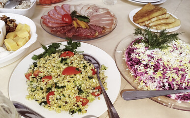Delicious spread of fresh salads and sliced meats at a festive gathering in a cozy setting