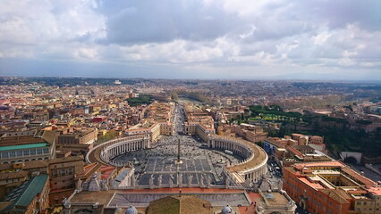 Rome, Italy - April 5 2018: Aerial view of St. Peter's Square featuring the grand colonnade, the tall obelisk, and a bustling crowd of tourists exploring this historic Vatican landmark
