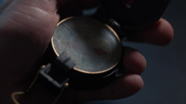 antique compass held in a hand pointing north