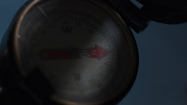 Antique compass, a little worn and with a red arrow