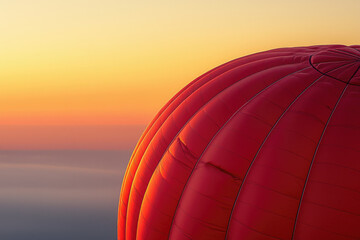 Obraz premium A vibrant red hot air balloon gracefully ascends against a breathtaking sunrise backdrop.