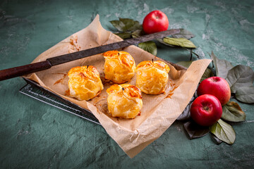 Traditional baked apples coated in pastry, decorated with pastry leaves and served as a close-up on...