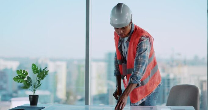 A worker is setting up interior plants in a modern office for better aesthetics and wellness