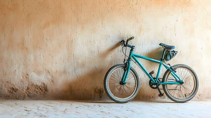 Teal bicycle leans against textured wall, travel adventure backdrop, tourism imagery