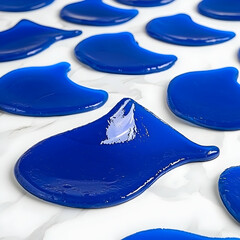 Obraz premium Blue liquid blobs on marble surface, close-up shot. Perfect for product, design, or abstract backgrounds