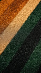 A close-up of dark green, rust orange, and beige stripes on artificial grass, with a warm golden background