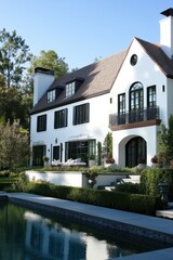 A stunning modern house, resplendent in white, is enveloped by lush greenery and features a tranquil pool, all set against a bright, sunny backdrop