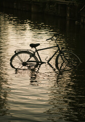 Abandoned Bicycle Reflection: Serene Urban Canal Landscape at Sunset