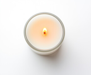 Minimalist white candle in glass container with soft flame, top view on clean background for wellness, spa, meditation or product mockup use